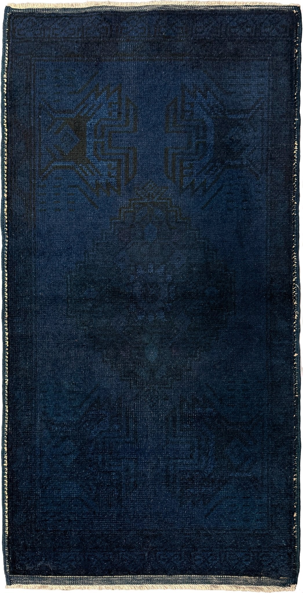 Turkish overdyed Yastik rug in deep indigo and midnight blue, with subtle tribal motifs visible beneath the saturated overdye. Hand-knotted wool, 20x45 inches. One-of-a-kind piece from Indigo Rugs, the best rug shop in the San Francisco Bay Area (Burlingame, CA). Free shipping included.
