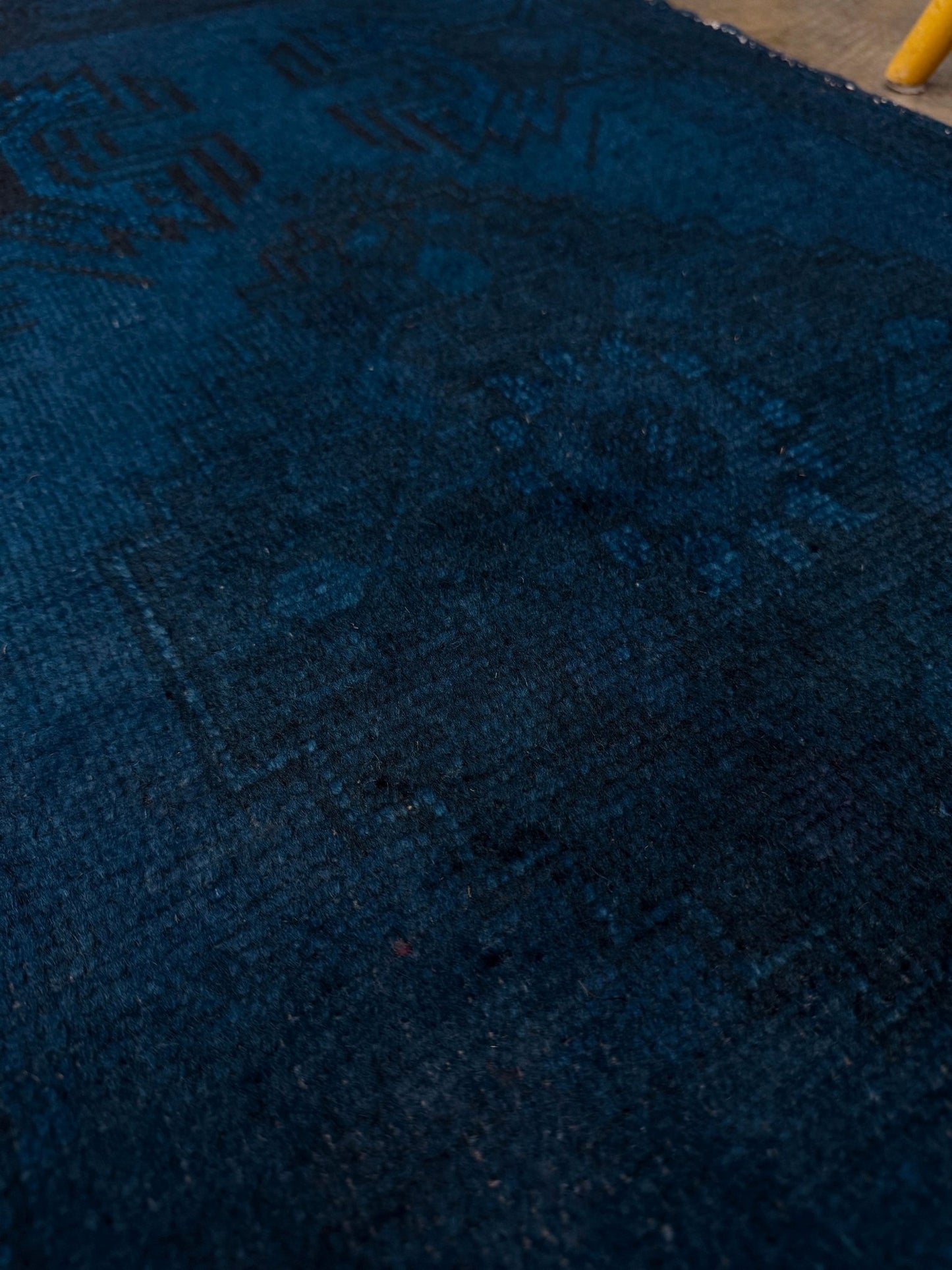 Turkish overdyed Yastik rug in deep indigo and midnight blue, with subtle tribal motifs visible beneath the saturated overdye. Hand-knotted wool, 20x40 inches. One-of-a-kind piece from Indigo Rugs, the best rug shop in the San Francisco Bay Area (Burlingame, CA). Free shipping included.