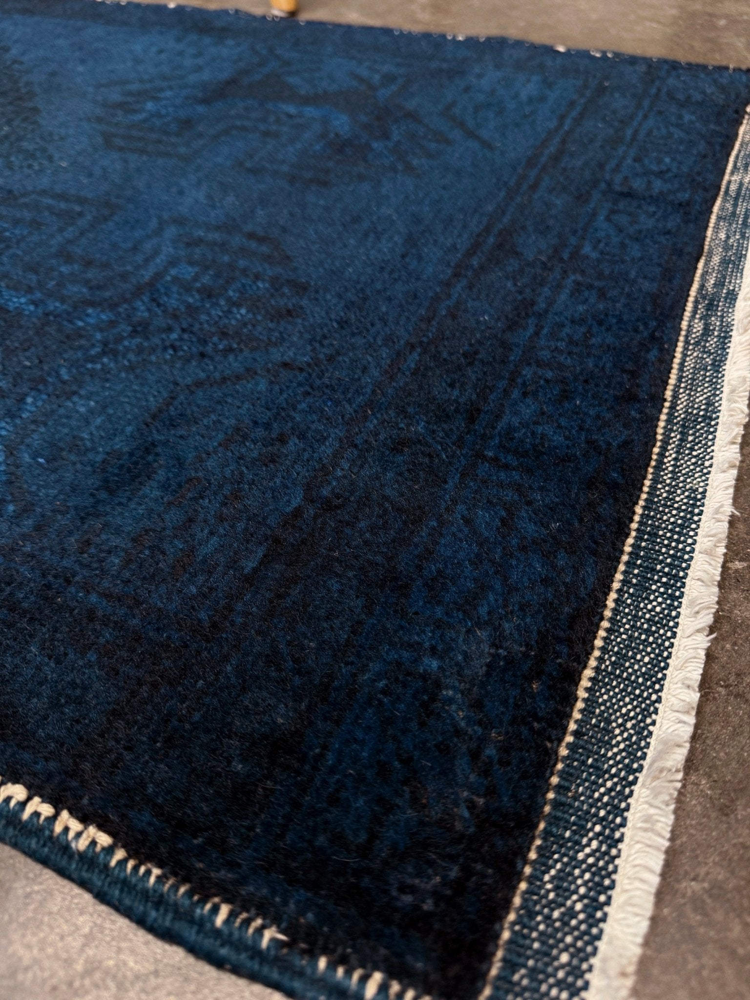Turkish overdyed Yastik rug in deep indigo and midnight blue, with subtle tribal motifs visible beneath the saturated overdye. Hand-knotted wool, 20x40 inches. One-of-a-kind piece from Indigo Rugs, the best rug shop in the San Francisco Bay Area (Burlingame, CA). Free shipping included.