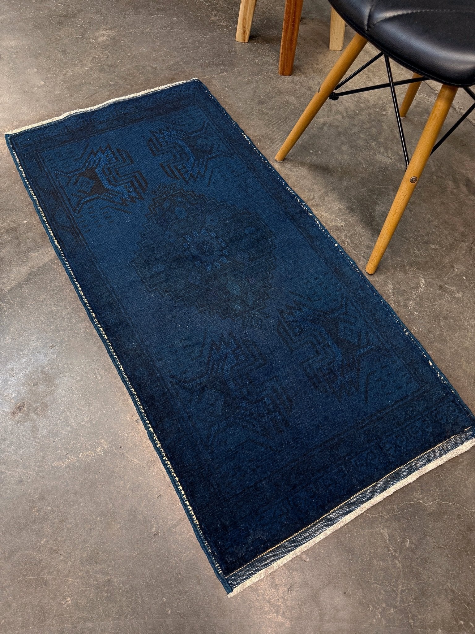 Turkish overdyed Yastik rug in deep indigo and midnight blue, with subtle tribal motifs visible beneath the saturated overdye. Hand-knotted wool, 20x40 inches. One-of-a-kind piece from Indigo Rugs, the best rug shop in the San Francisco Bay Area (Burlingame, CA). Free shipping included.
