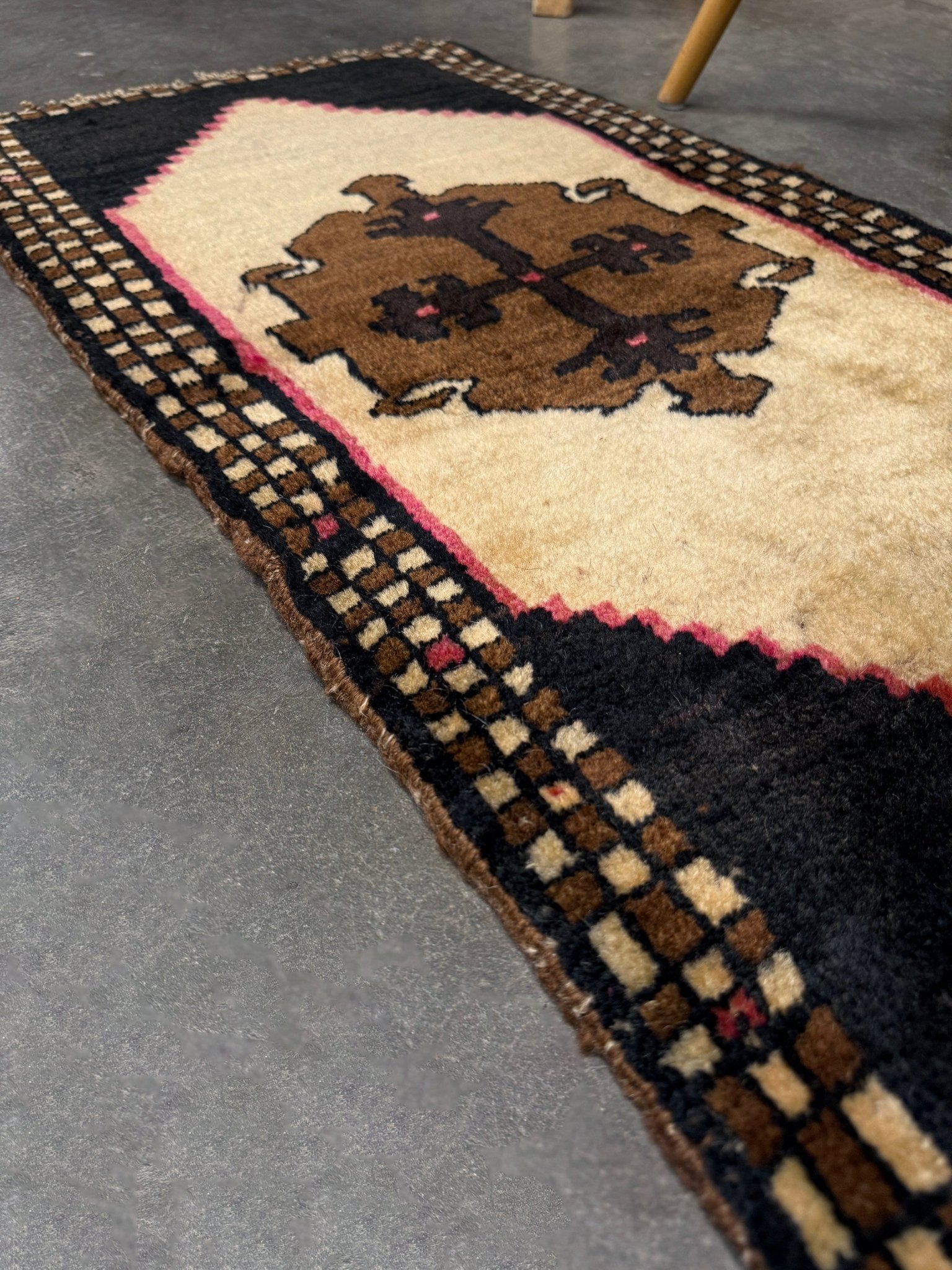 Neurtal Vintage Turkish mini rug 2x3, perfect for entryways, bedside, or layered décor. with a soft ivory field and bold geometric medallion in warm brown tones, framed by a deep cocoa-brown border with subtle brick-red accents. Handmade Anatolian wool rug,  From Indigo Rugs, Burlingame, San Francisco Bay Area.