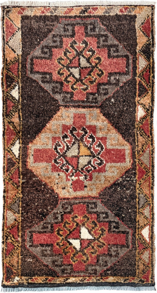Vintage Turkish mini rug 21x39 with terracotta and brown geometric medallion design, handmade wool rug with earthy tones, perfect for entryway or bedside, from Indigo Rugs in the San Francisco Bay Area.