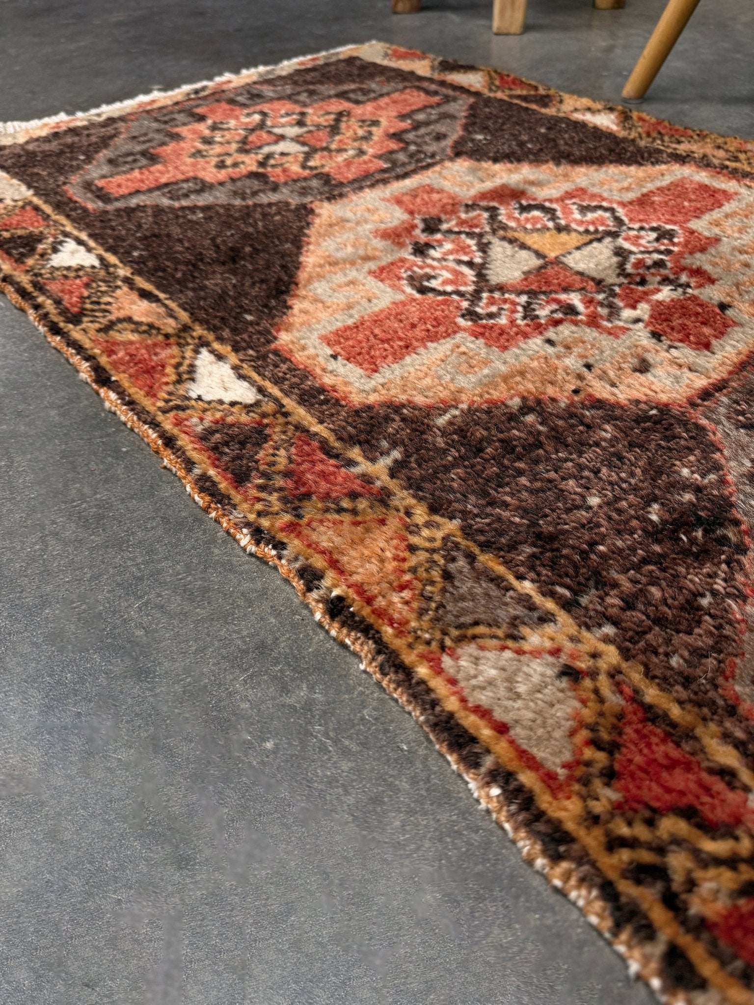 Vintage Turkish mini rug 21x39 with terracotta and brown geometric medallion design, handmade wool rug with earthy tones, perfect for entryway or bedside, from Indigo Rugs in the San Francisco Bay Area.