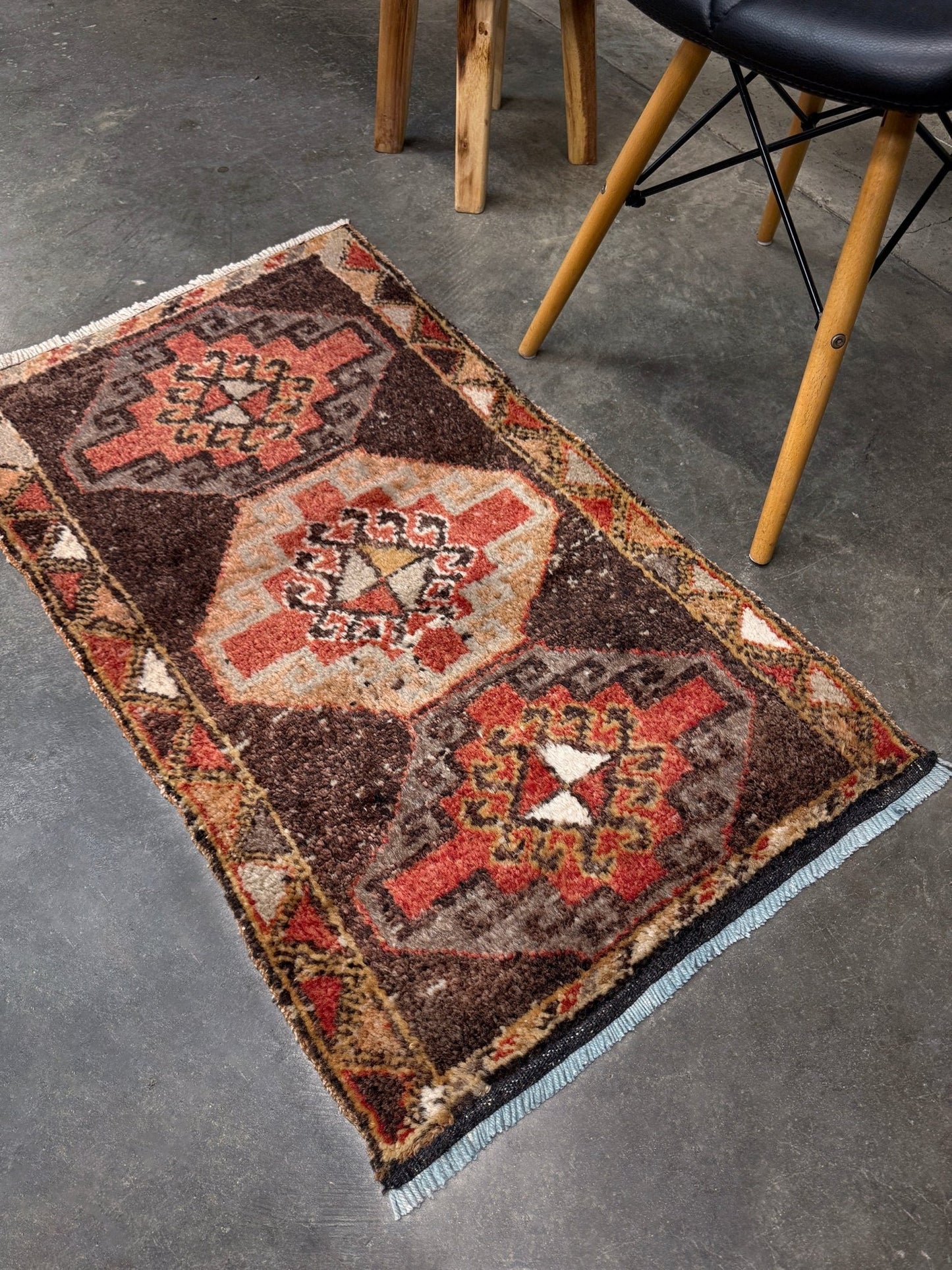 Vintage Turkish mini rug 21x39 with terracotta and brown geometric medallion design, handmade wool rug with earthy tones, perfect for entryway or bedside, from Indigo Rugs in the San Francisco Bay Area.