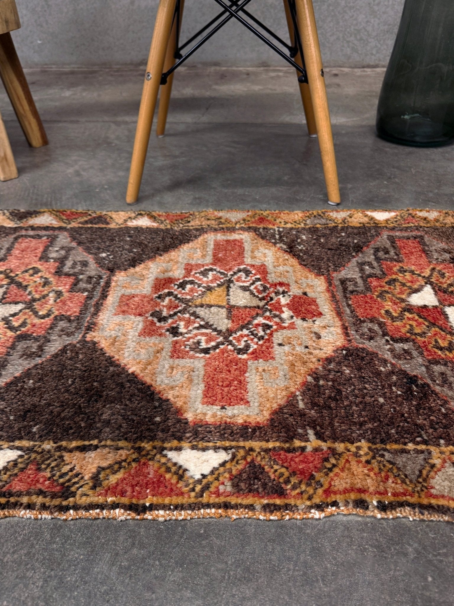 Vintage Turkish mini rug 21x39 with terracotta and brown geometric medallion design, handmade wool rug with earthy tones, perfect for entryway or bedside, from Indigo Rugs in the San Francisco Bay Area.