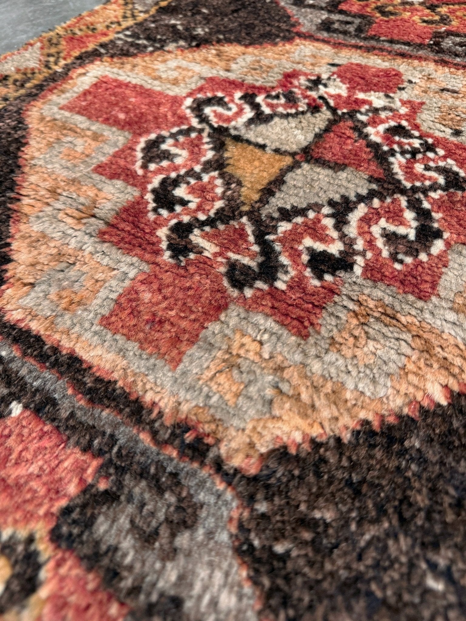 Vintage Turkish mini rug 21x39 with terracotta and brown geometric medallion design, handmade wool rug with earthy tones, perfect for entryway or bedside, from Indigo Rugs in the San Francisco Bay Area.