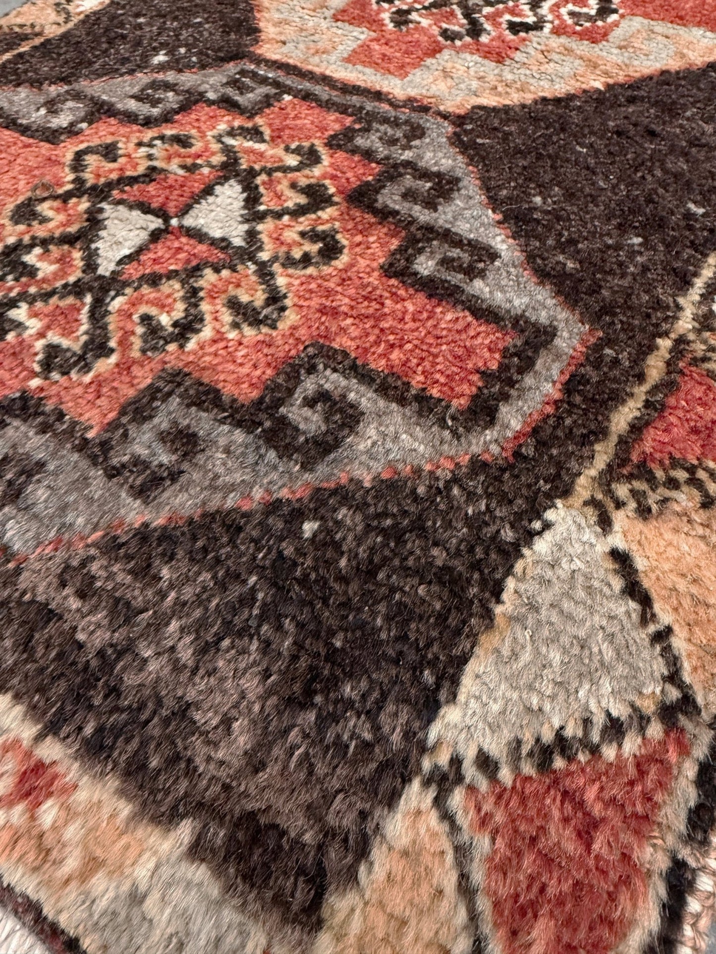 Vintage Turkish mini rug 21x39 with terracotta and brown geometric medallion design, handmade wool rug with earthy tones, perfect for entryway or bedside, from Indigo Rugs in the San Francisco Bay Area.