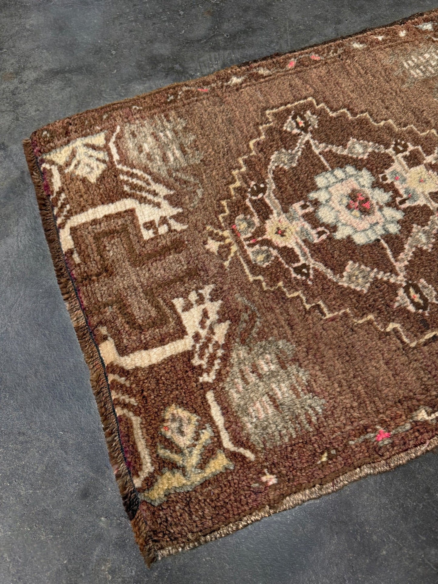 Vintage Turkish mini rug with earthy brown field and soft ivory geometric medallion, hand-knotted wool Anatolian village rug, 19x30 small accent rug for bedside, entryway, or wall art. From Indigo Rugs, Burlingame — San Francisco Bay Area.