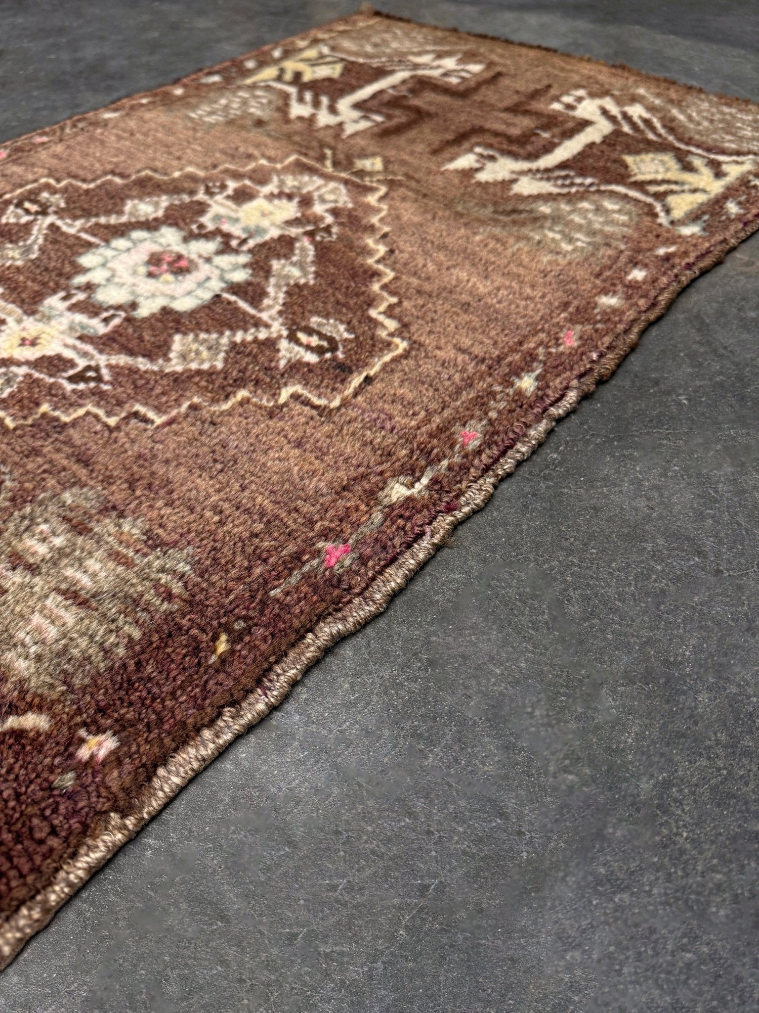 Vintage Turkish mini rug with earthy brown field and soft ivory geometric medallion, hand-knotted wool Anatolian village rug, 19x30 small accent rug for bedside, entryway, or wall art. From Indigo Rugs, Burlingame — San Francisco Bay Area.