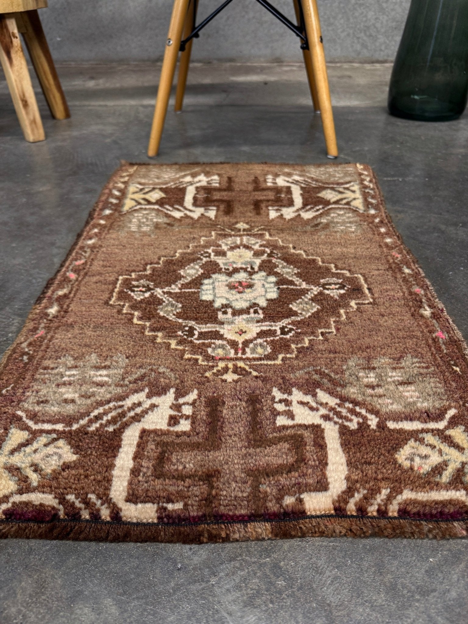 Vintage Turkish mini rug with earthy brown field and soft ivory geometric medallion, hand-knotted wool Anatolian village rug, 19x30 small accent rug for bedside, entryway, or wall art. From Indigo Rugs, Burlingame — San Francisco Bay Area.