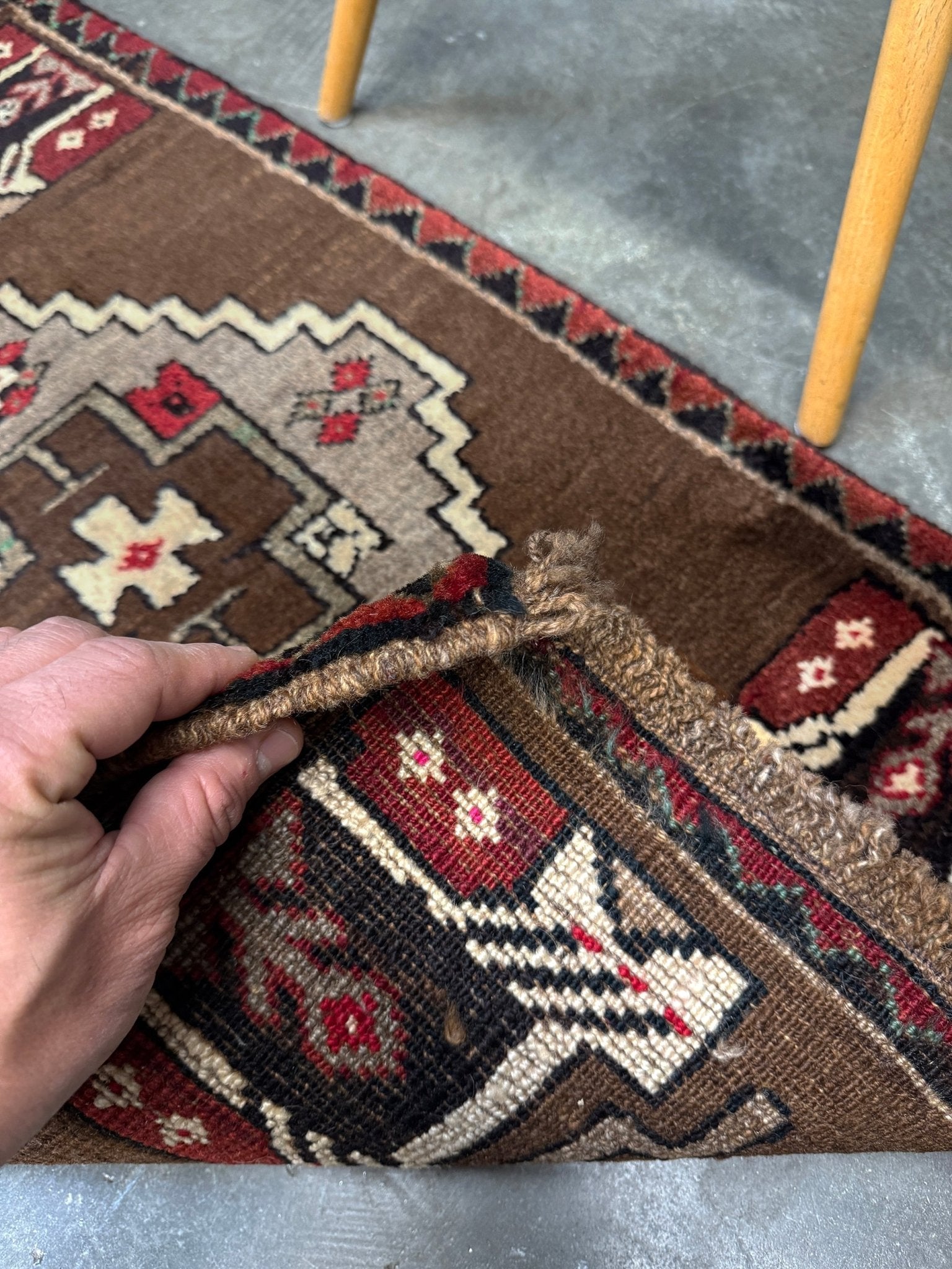 Vintage Turkish Yastik mini rug in walnut brown with taupe and camel medallion, espresso outlines, ivory highlights, and crimson red accents. Hand-knotted wool, 21x37 inches. One-of-a-kind rug from Indigo Rugs, the best rug shop in the San Francisco Bay Area (Burlingame, CA). Free shipping included.