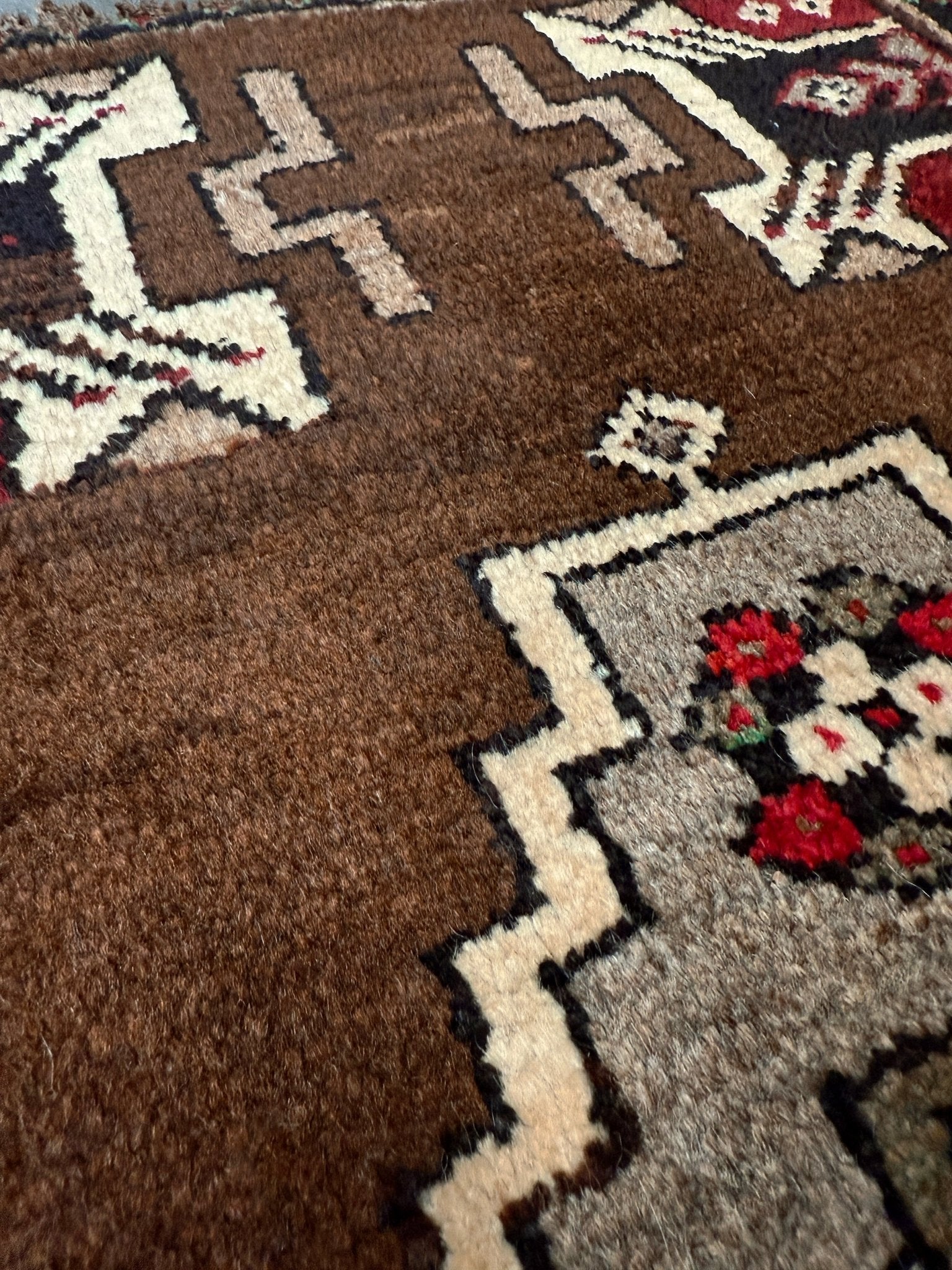 Vintage Turkish Yastik mini rug in walnut brown with taupe and camel medallion, espresso outlines, ivory highlights, and crimson red accents. Hand-knotted wool, 21x37 inches. One-of-a-kind rug from Indigo Rugs, the best rug shop in the San Francisco Bay Area (Burlingame, CA). Free shipping included.