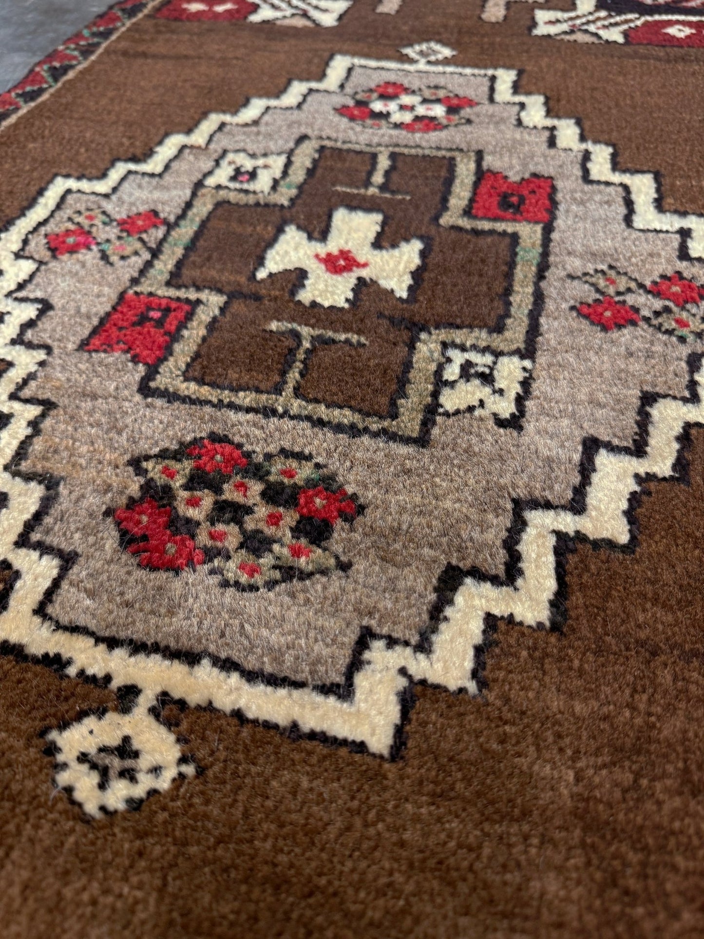 Vintage Turkish Yastik mini rug in walnut brown with taupe and camel medallion, espresso outlines, ivory highlights, and crimson red accents. Hand-knotted wool, 21x37 inches. One-of-a-kind rug from Indigo Rugs, the best rug shop in the San Francisco Bay Area (Burlingame, CA). Free shipping included.
