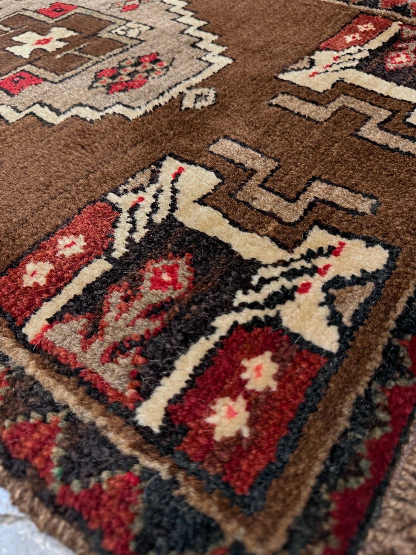 Vintage Turkish Yastik mini rug in walnut brown with taupe and camel medallion, espresso outlines, ivory highlights, and crimson red accents. Hand-knotted wool, 21x37 inches. One-of-a-kind rug from Indigo Rugs, the best rug shop in the San Francisco Bay Area (Burlingame, CA). Free shipping included.